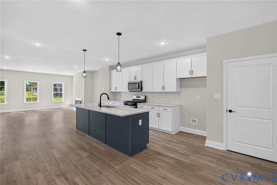 6541 Hardee Haven Place, Midlothian, VA 23112 Open-concept kitchen with a central island, white cabinetry, integrated stainless steel appliances, and wood-finish flooring