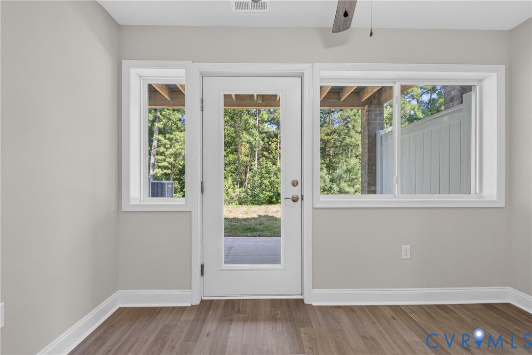 6541 Hardee Haven Place, Midlothian, VA 23112 Wood-finish flooring, light grey wall paint, multiple windows, and a glass-paneled exterior door