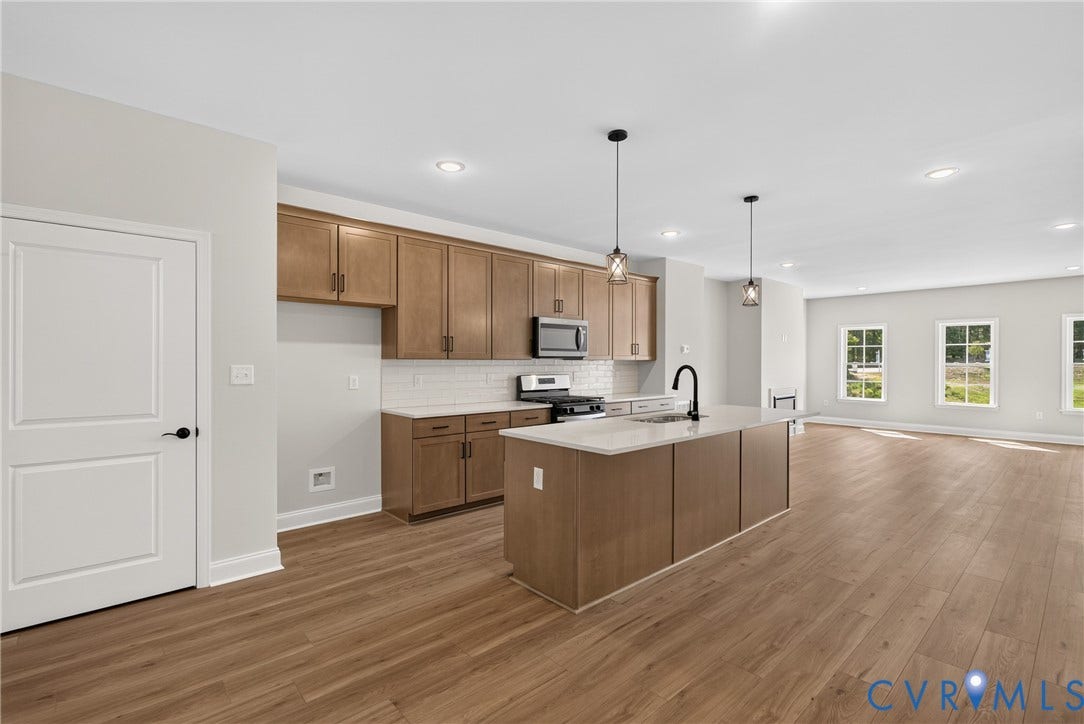 6545 Hardee Haven Place, Midlothian, VA 23112 Open concept kitchen featuring wood-finish flooring, recessed lighting, a kitchen island with pendant lighting, and a subway tile backsplash