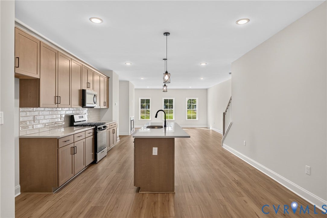 6545 Hardee Haven Place, Midlothian, VA 23112 Kitchen with wood-finish flooring, light-toned cabinetry, stainless steel appliances, a white subway tile backsplash, and a central island with a sink and pendant lighting