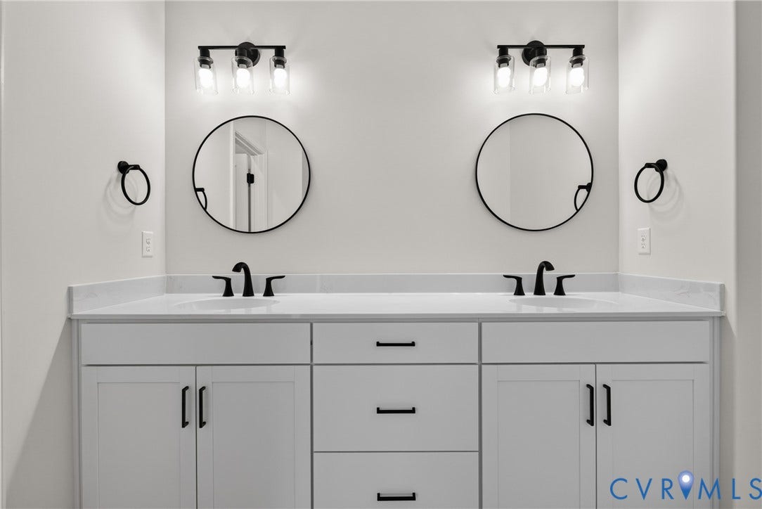 6545 Hardee Haven Place, Midlothian, VA 23112 Dual white vanities with integrated sinks, white countertops, matte black faucets, and round mirrors