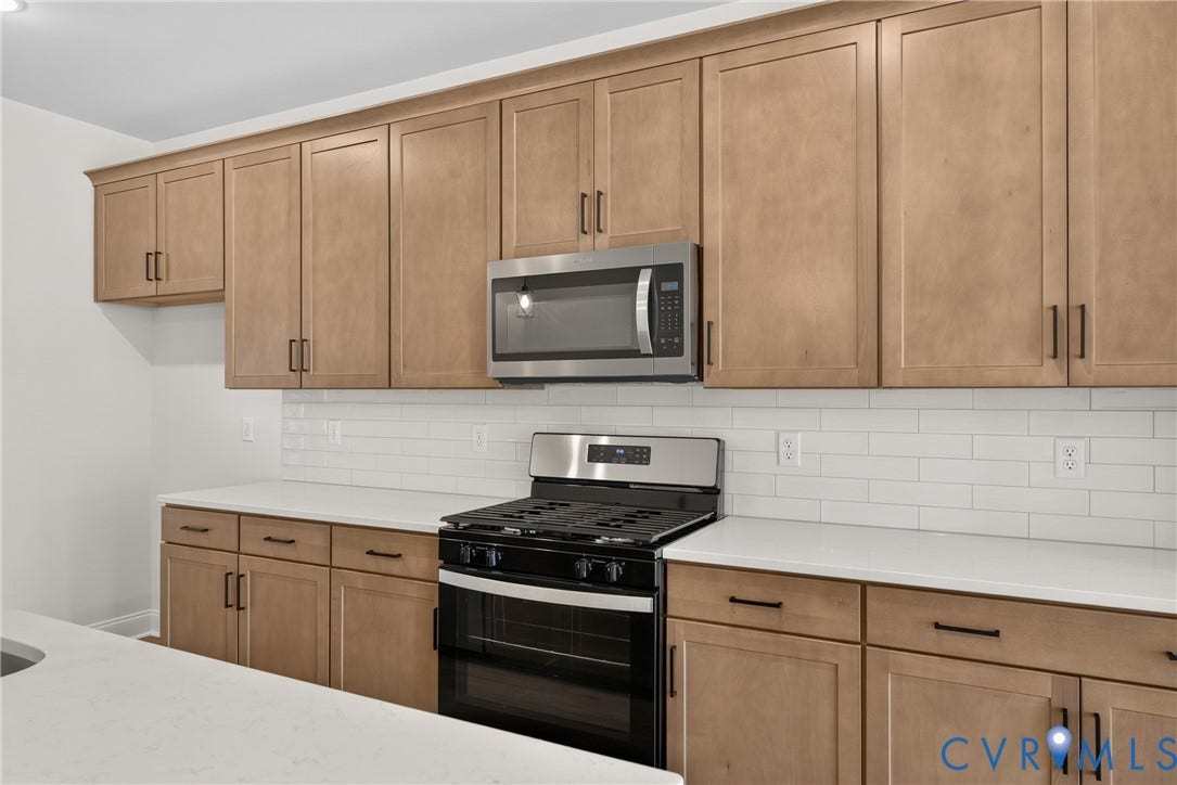 6545 Hardee Haven Place, Midlothian, VA 23112 Stainless steel microwave, stainless steel range with oven, white subway tile backsplash, light wood-finish cabinetry, and white countertops