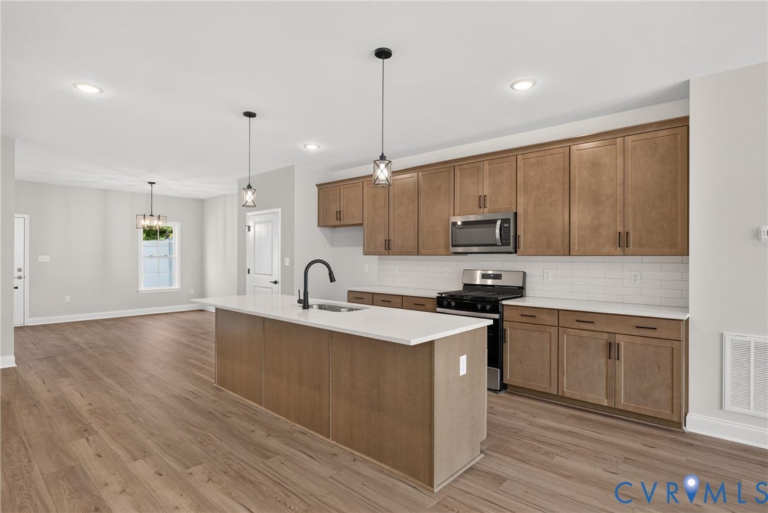 6545 Hardee Haven Place, Midlothian, VA 23112 Kitchen featuring a central island with countertop, wood-finish flooring, stainless steel appliances, and wood cabinetry