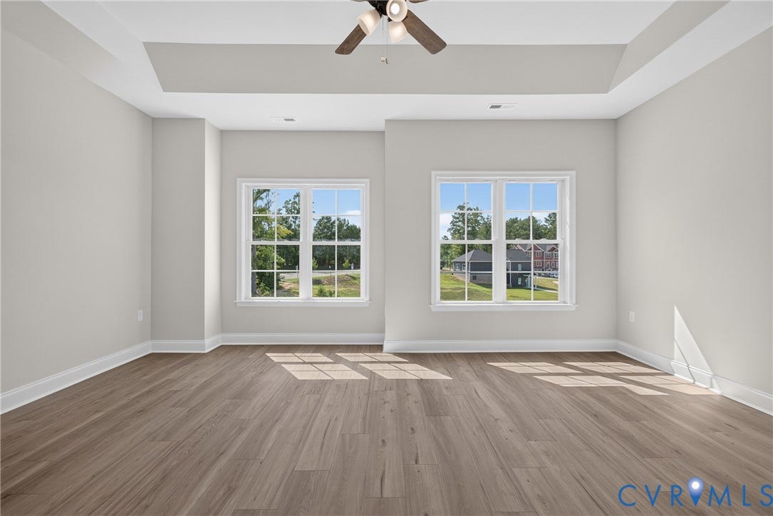 6545 Hardee Haven Place, Midlothian, VA 23112 Tray ceiling with a ceiling fan, two windows with white trim, and wood-finish flooring