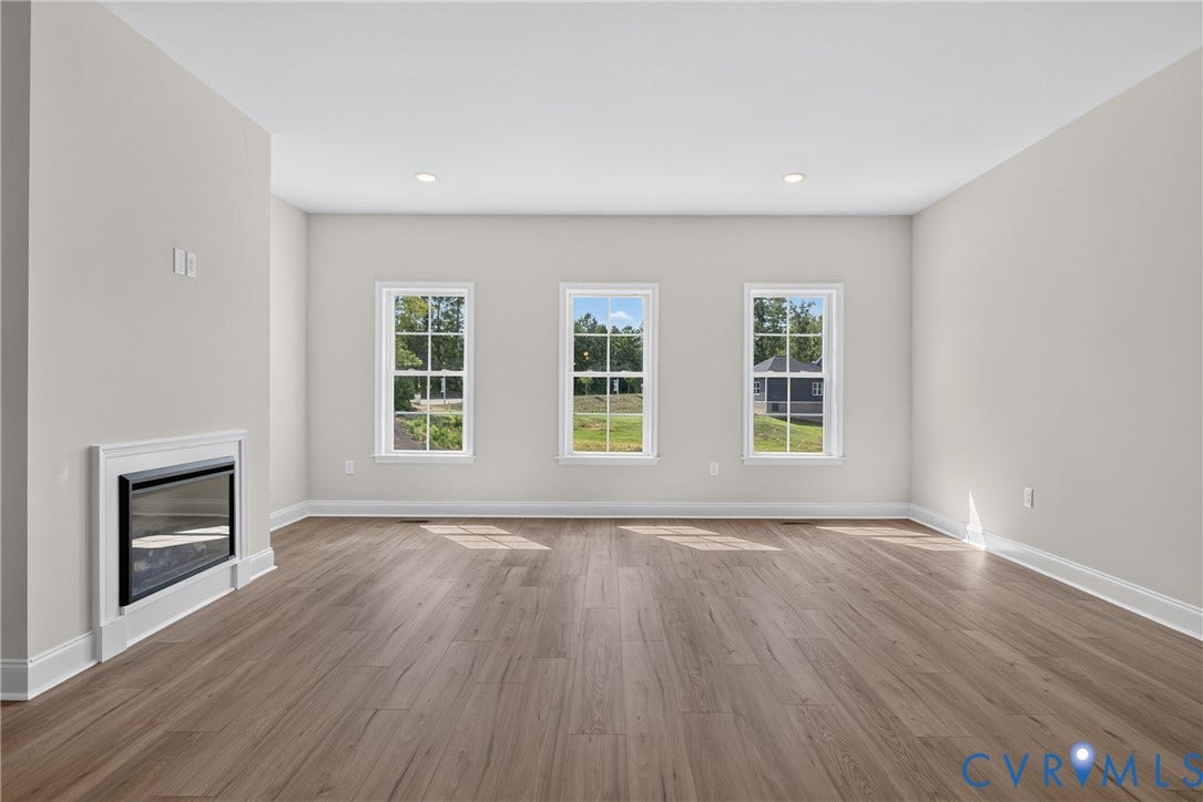 6545 Hardee Haven Place, Midlothian, VA 23112 Recessed electric fireplace, wood-finish flooring, three double-hung windows, recessed ceiling lighting, and crisp white trim