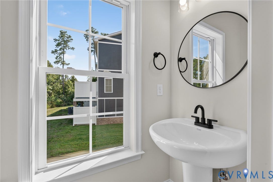 6549 Hardee Haven Place, Midlothian, VA 23112 Pedestal sink with matte black faucet, framed mirror, and natural light from a double-hung window