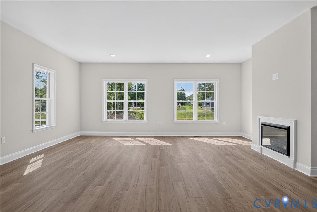 6549 Hardee Haven Place, Midlothian, VA 23112 Spacious interior with wood-finish flooring, recessed lighting, multiple windows, and a built-in fireplace feature
