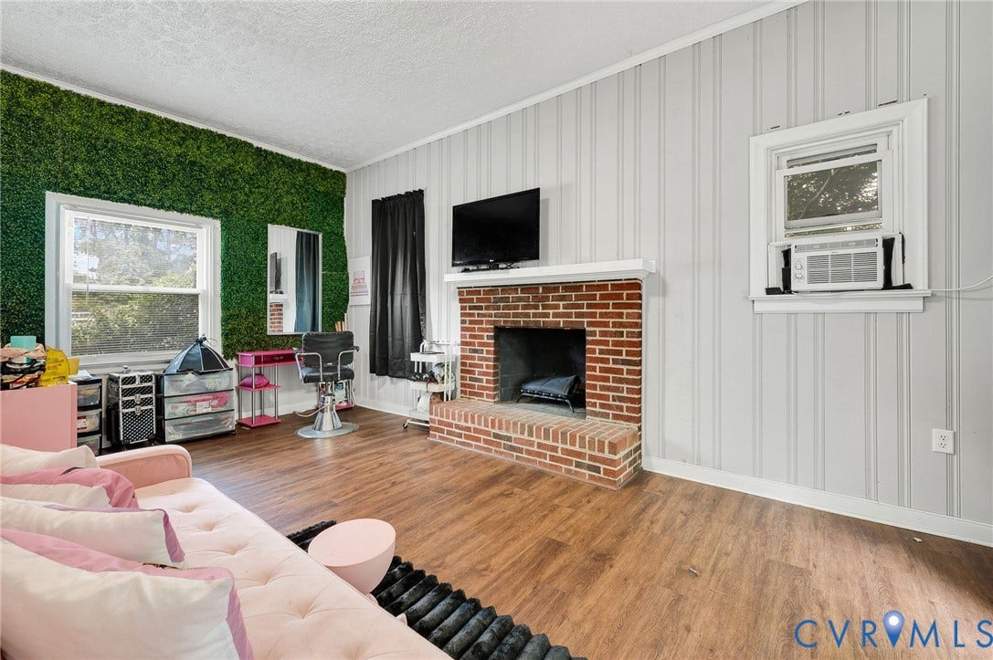 4819 Arundel Avenue, Chesterfield, VA 23234 Brick fireplace with a white mantel, wood-finish flooring, and vertical paneling