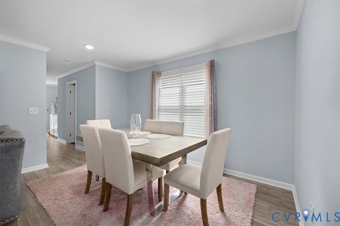 Recessed lighting, crown molding, light wood-finish flooring, and a large window with blinds