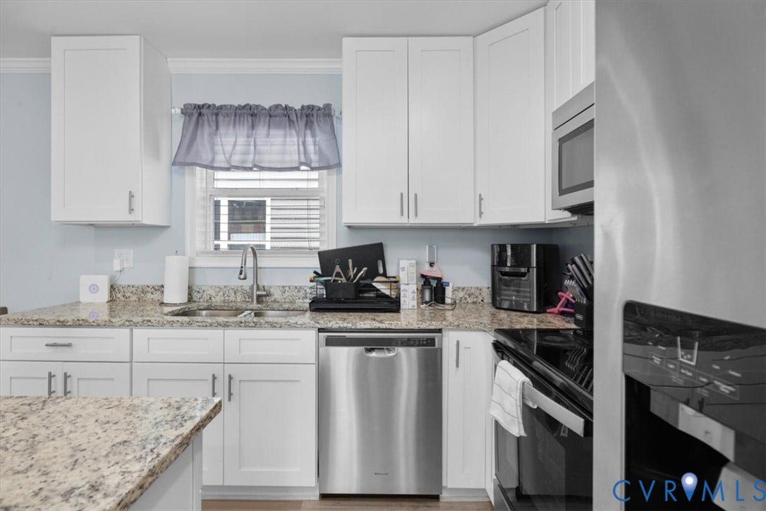 White shaker-style cabinetry, stainless steel dishwasher, stainless steel microwave, granite-look countertops, and stainless steel sink with a gooseneck faucet