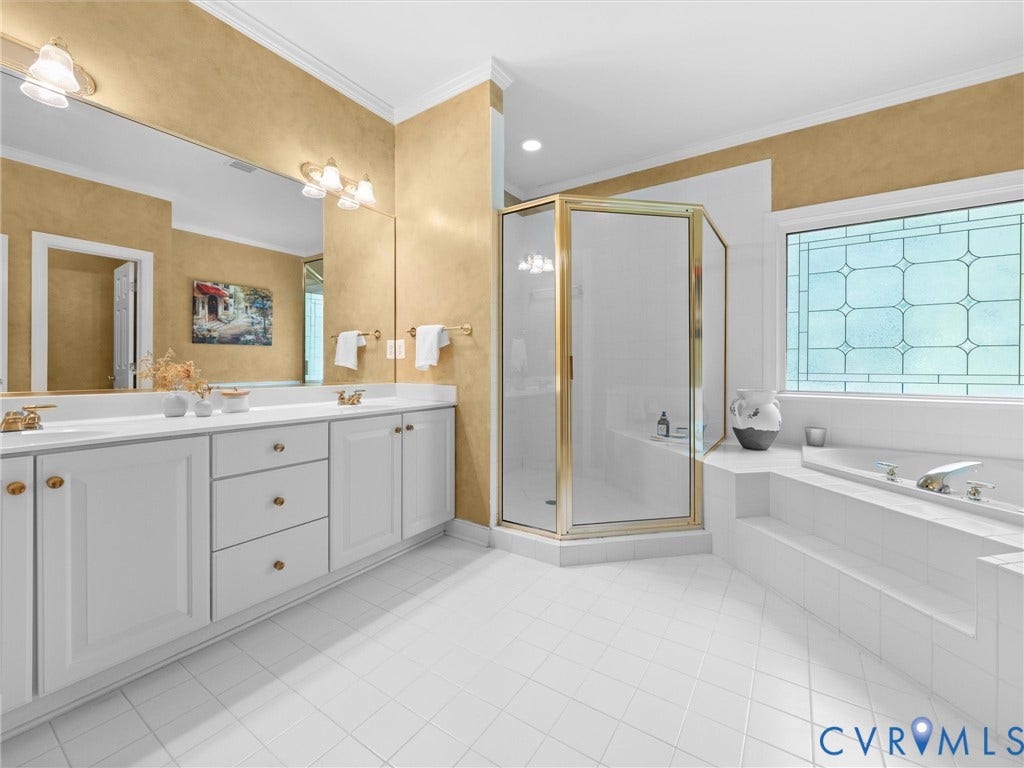15706 Fox Marsh Drive, Moseley, VA 23120 Spacious bathroom featuring a double vanity with white cabinetry, a glass-enclosed shower, a built-in tub, and decorative window