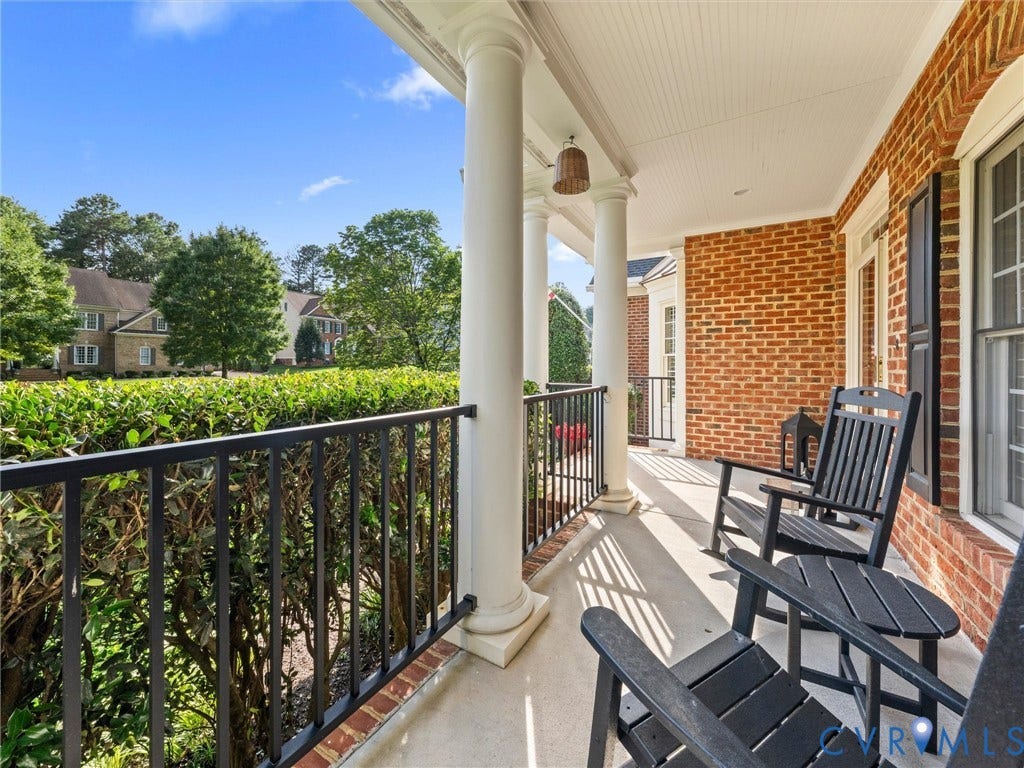 15706 Fox Marsh Drive, Moseley, VA 23120 Covered porch with classic white columns, red brick exterior, and black metal railing