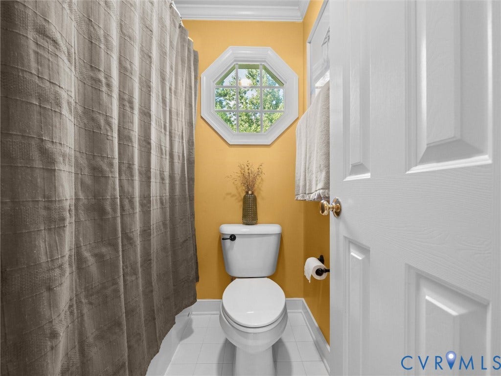 15706 Fox Marsh Drive, Moseley, VA 23120 Octagonal window providing natural light, white crown molding, white panel door, white toilet, and white tile flooring
