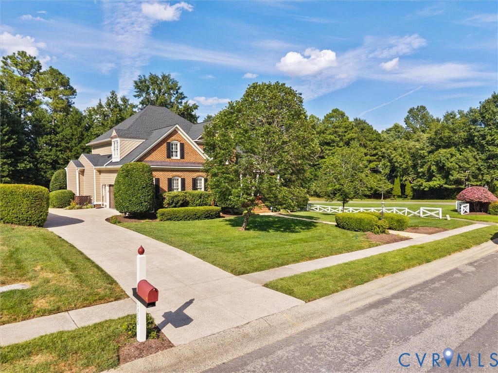 15706 Fox Marsh Drive, Moseley, VA 23120 Brick and siding exterior with dark shutters, established landscaping, paved driveway, and manicured lawn