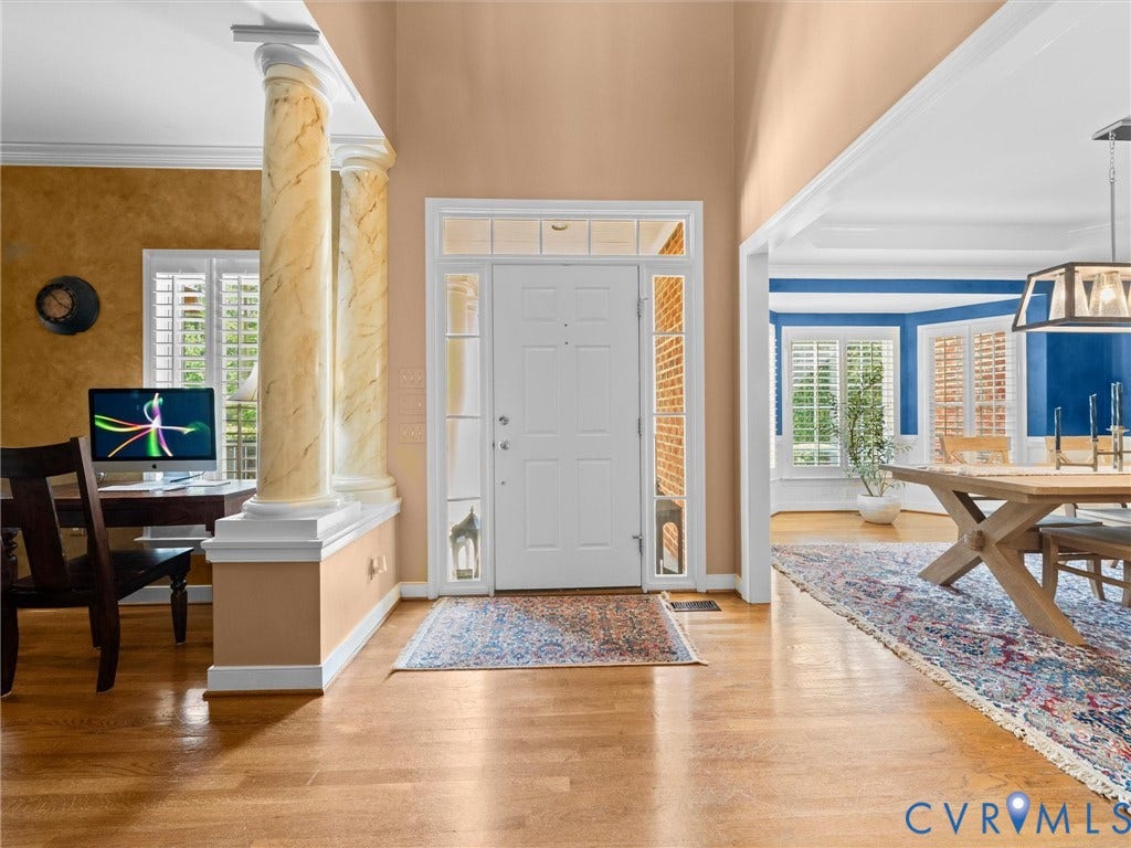 15706 Fox Marsh Drive, Moseley, VA 23120 Hardwood flooring throughout, decorative columns with marble-look finish, transom window above the entry door, sidelight windows, and crown molding