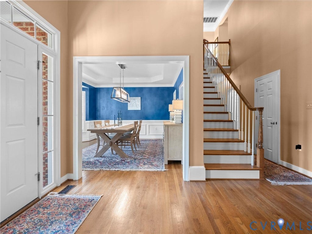 15706 Fox Marsh Drive, Moseley, VA 23120 Foyer featuring a paneled entry door with sidelights and transom, wood-finish flooring, and a staircase with wood treads and a wood handrail