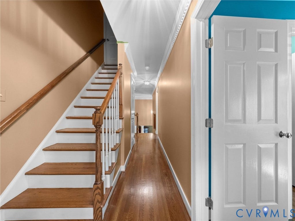 15706 Fox Marsh Drive, Moseley, VA 23120 Hardwood staircase with white risers and wood handrails, crown molding, and wood-finish flooring