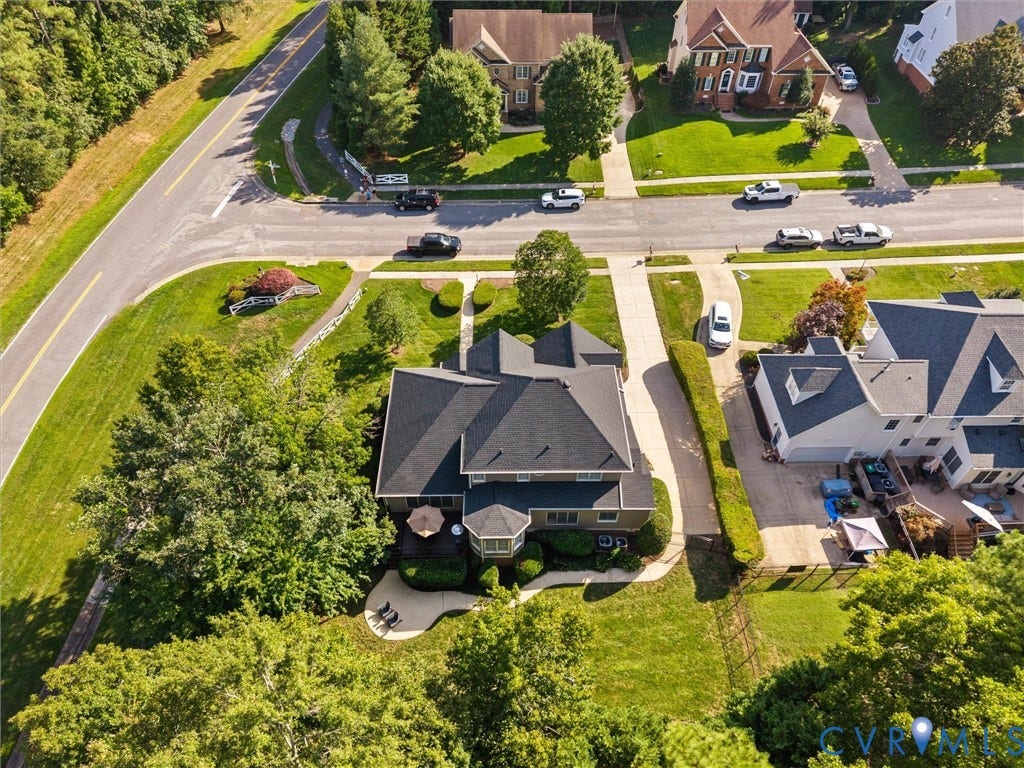 15706 Fox Marsh Drive, Moseley, VA 23120 Expansive property featuring a multi-story residence with a dark shingle roof, a curving paved driveway, and a backyard patio