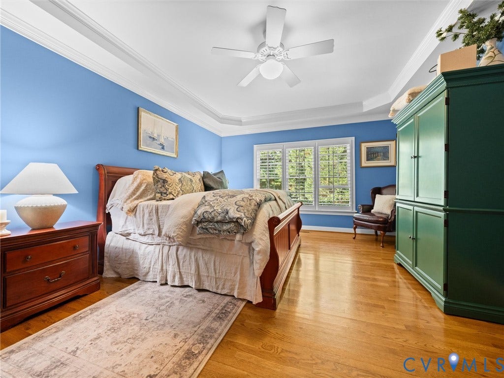 15706 Fox Marsh Drive, Moseley, VA 23120 Hardwood flooring, tray ceiling, ceiling fan, and large windows with plantation shutters