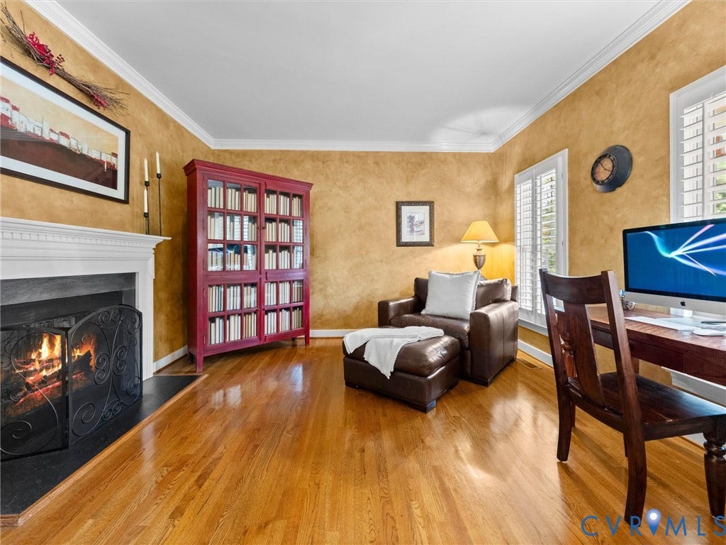 15706 Fox Marsh Drive, Moseley, VA 23120 Hardwood flooring, white crown molding, fireplace with white mantel, built-in cabinetry, and window shutters