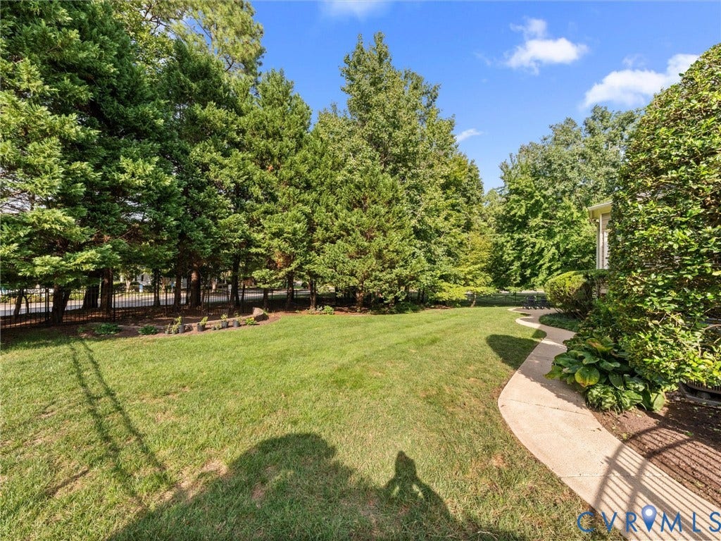15706 Fox Marsh Drive, Moseley, VA 23120 Expansive lawn with mature perimeter trees, a curved concrete pathway, and established plantings