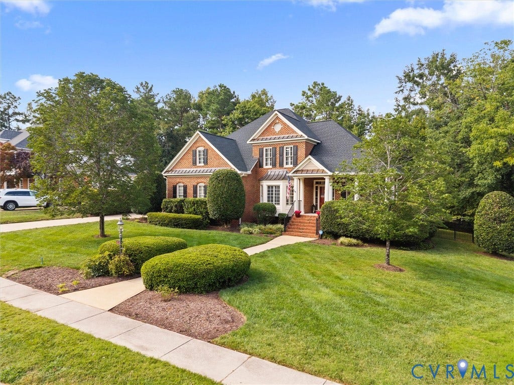 15706 Fox Marsh Drive, Moseley, VA 23120 Brick Colonial residence showcasing a manicured front landscape with mature boxwood hedges, curved brick walkway, and lush lawn