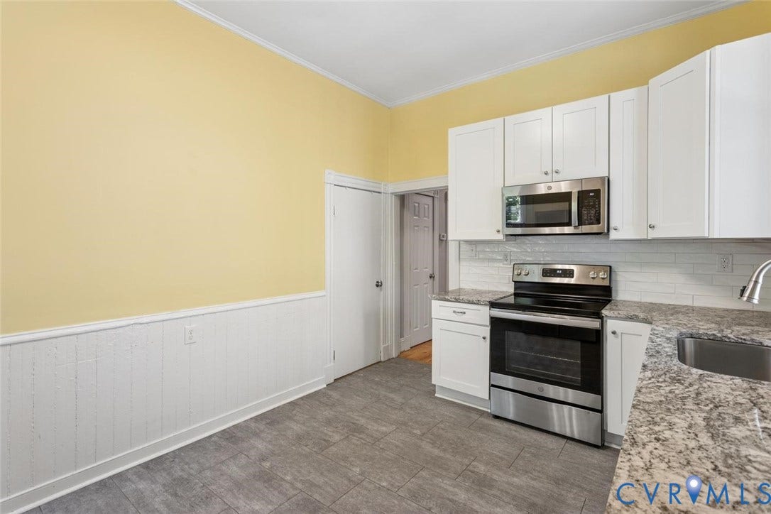 313 W 27th Street, Richmond, VA 23225 White shaker-style cabinetry, stainless steel appliances, tiled flooring, granite countertops, and subway tile backsplash