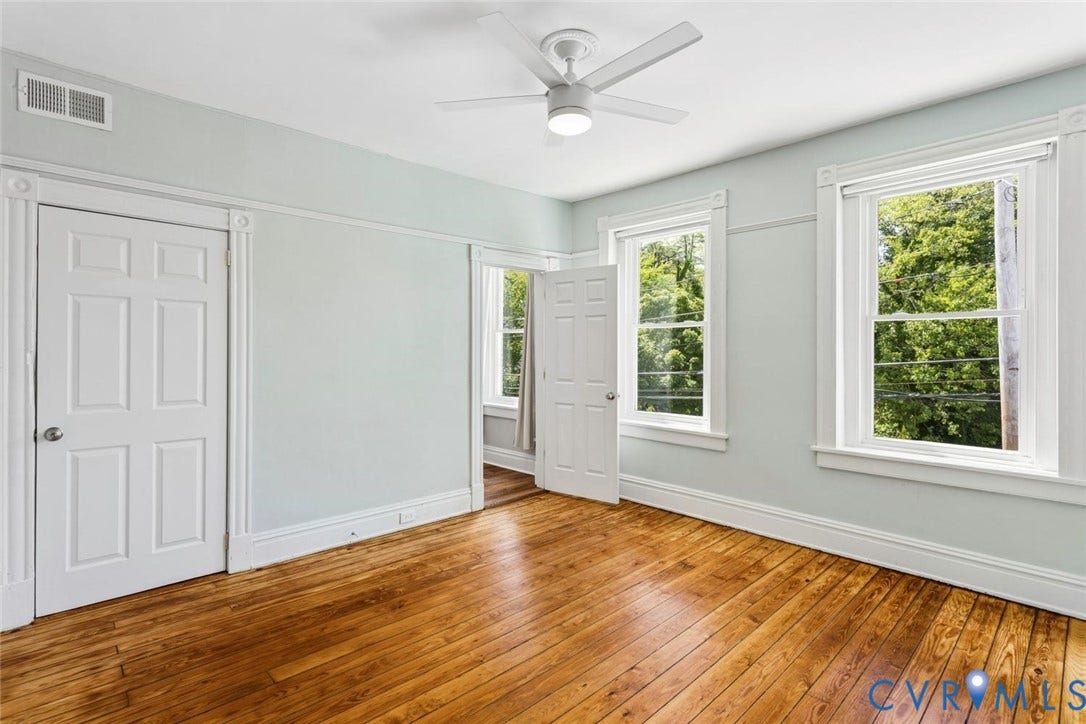 313 W 27th Street, Richmond, VA 23225 Hardwood flooring, painted trim molding, ceiling fan with integrated lighting, multiple windows, and a six-panel door