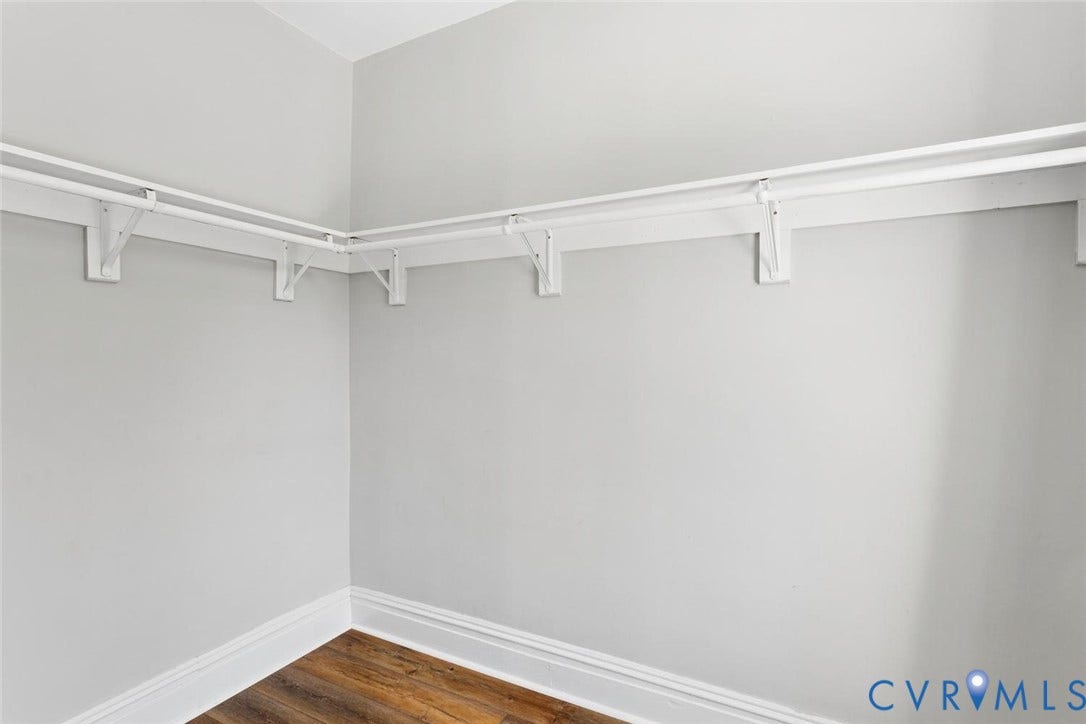 313 W 27th Street, Richmond, VA 23225 Wall-mounted storage rods with supporting brackets, painted light gray walls, and wood-finish flooring
