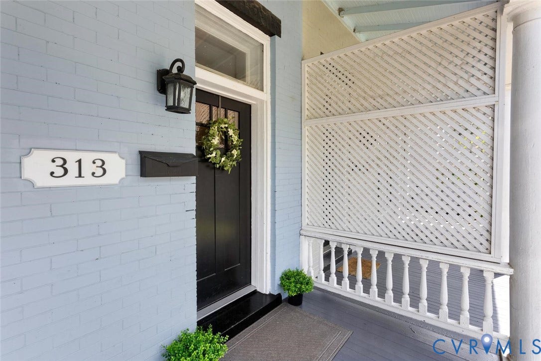 313 W 27th Street, Richmond, VA 23225 Brick exterior with a dark entry door, transom window, and a decorative outdoor light fixture