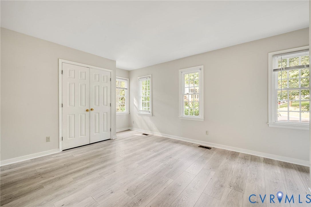 4820 Cedar Cliff Road, Chester, VA 23831 Light-toned walls, wood-finish flooring, white window frames, double bifold doors, and white trim