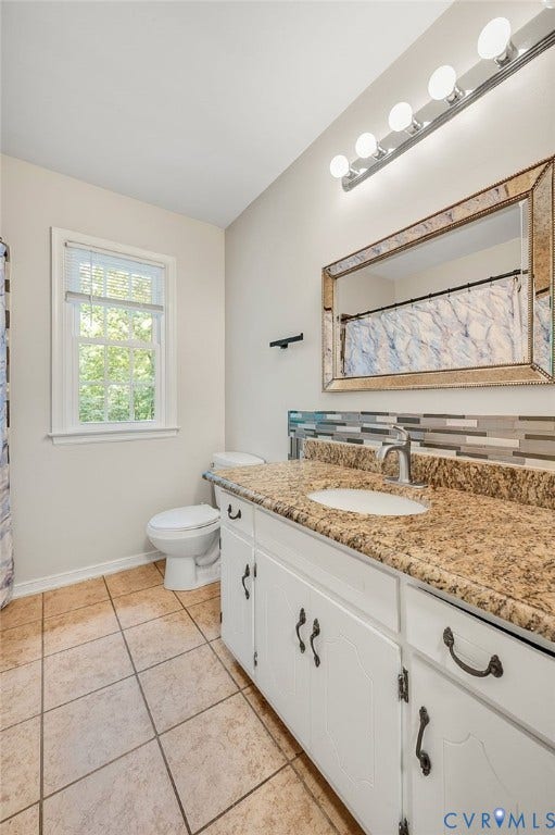 4820 Cedar Cliff Road, Chester, VA 23831 Bright bathroom featuring a granite-topped vanity with dual sink basin, white cabinetry with oil-rubbed bronze hardware, and ceramic tile flooring