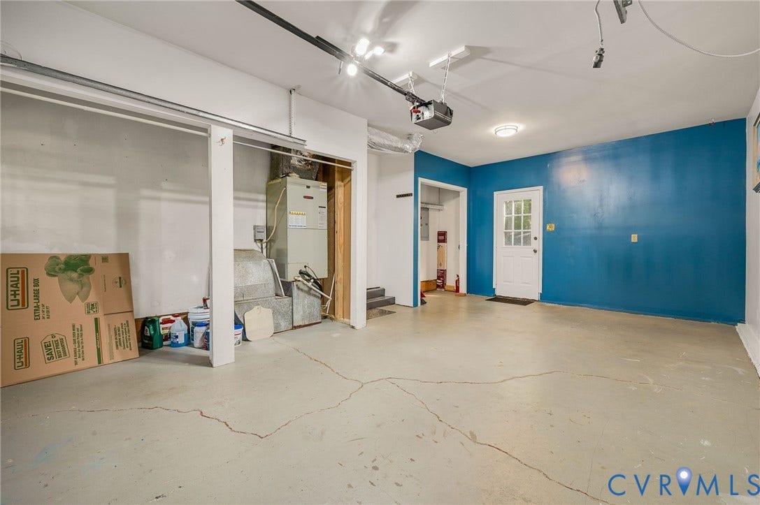4820 Cedar Cliff Road, Chester, VA 23831 Spacious garage with an overhead automatic door opener, track lighting, and a utility closet
