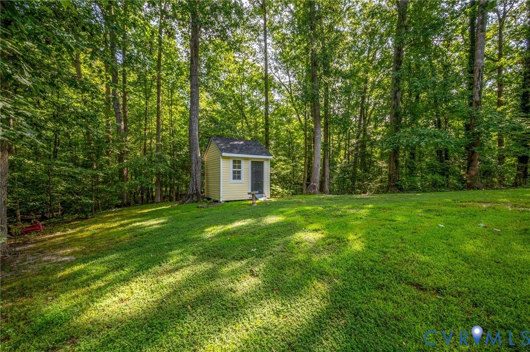 4820 Cedar Cliff Road, Chester, VA 23831 Expansive lawn with mature trees and a detached shed featuring siding and a single window