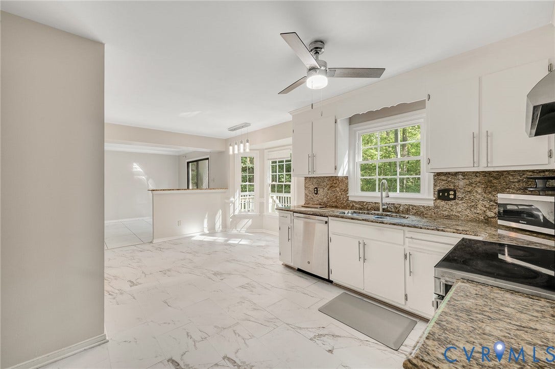 4820 Cedar Cliff Road, Chester, VA 23831 Bright, open-concept kitchen featuring white cabinetry with chrome hardware, stainless steel appliances, granite-style countertops with decorative tile backsplash, and polished marble-finish flooring