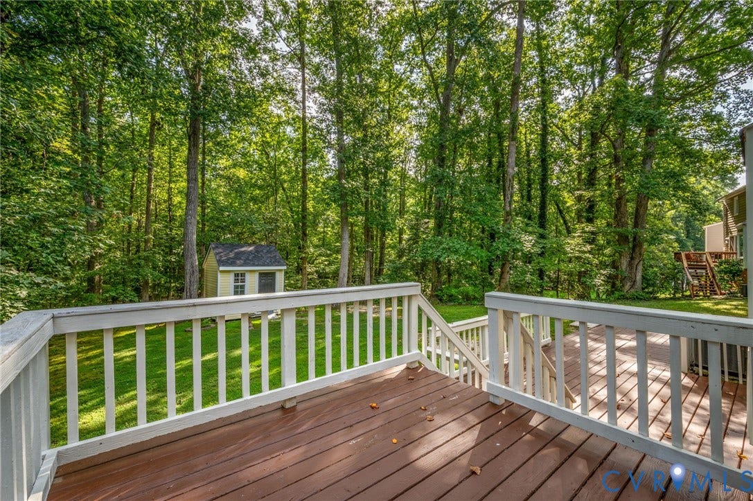4820 Cedar Cliff Road, Chester, VA 23831 Expansive wood-finish deck with white railing overlooking a grassy yard with mature trees and a storage shed