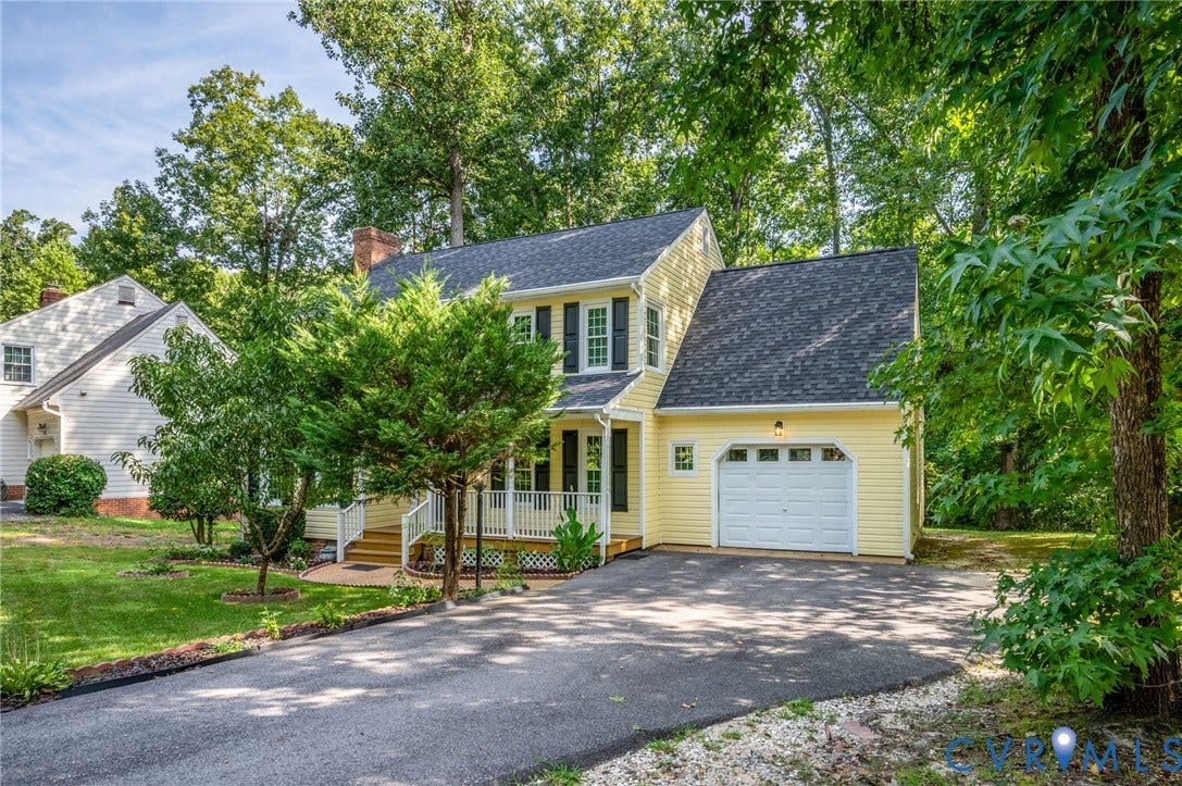 4820 Cedar Cliff Road, Chester, VA 23831 Yellow siding exterior with dark shutters, attached garage, covered front porch, and mature trees