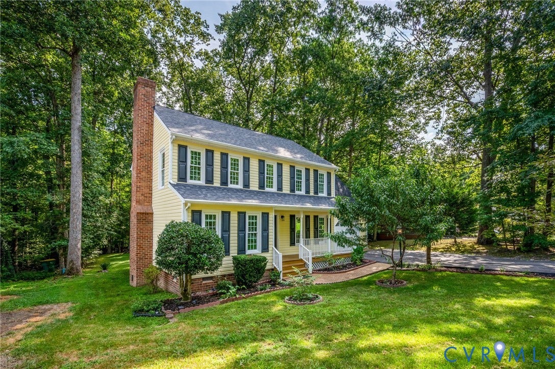 4820 Cedar Cliff Road, Chester, VA 23831 Two-story residence featuring light yellow siding, a prominent brick chimney, and a front porch with white railings