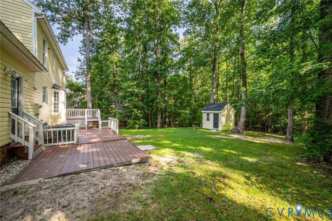 4820 Cedar Cliff Road, Chester, VA 23831 Expansive backyard featuring a large wood deck, manicured lawn, and mature trees