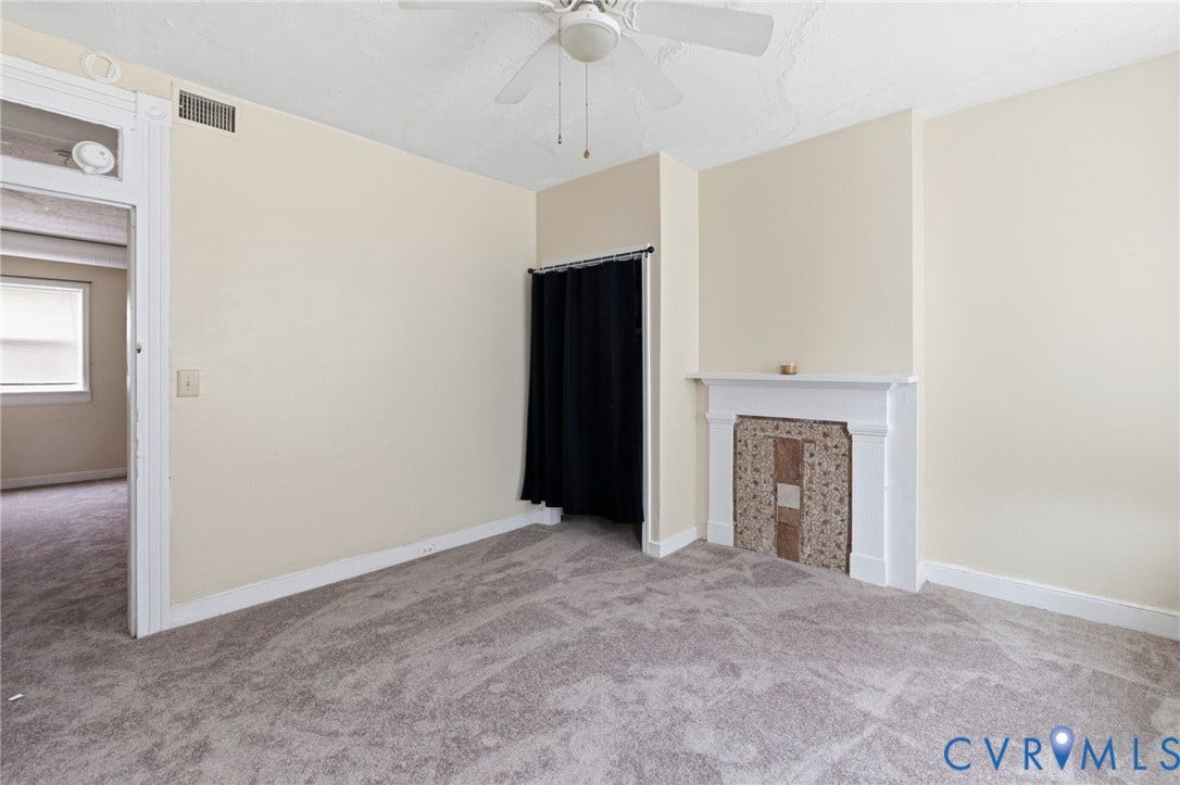 1202 1/2 W Clay Street, Richmond, VA 23220 Neutral-toned wall paint, textured carpeting, and a ceiling fan