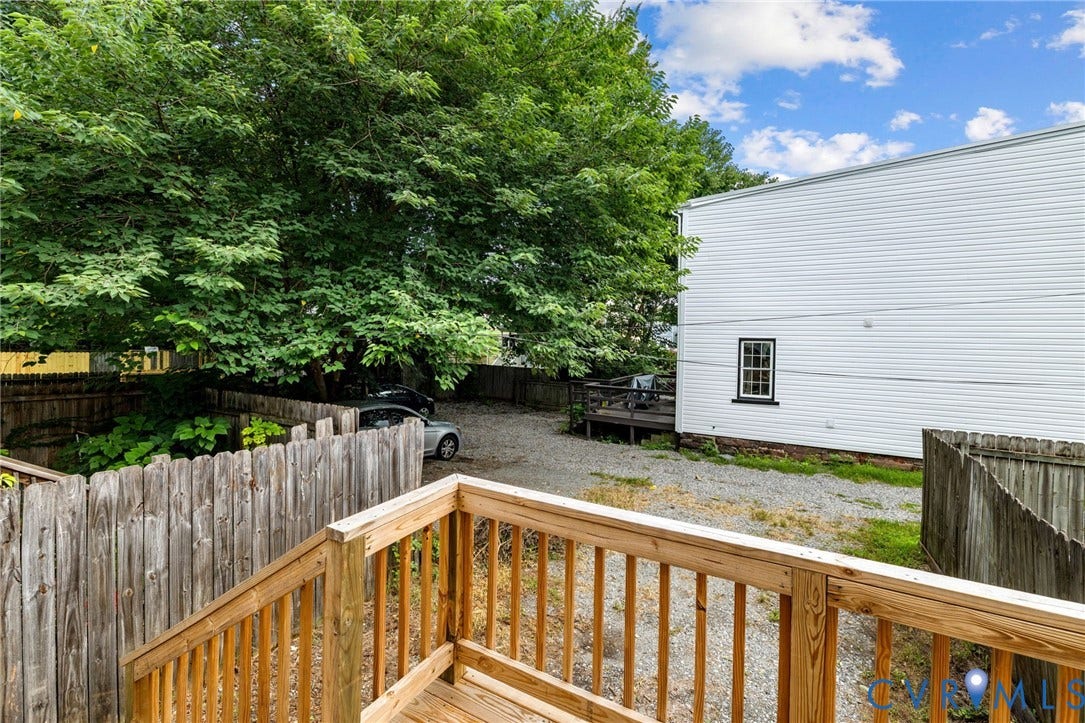 1202 1/2 W Clay Street, Richmond, VA 23220 Spacious composite deck with turned wood railings and balusters overlooking a fenced yard with mature tree canopy