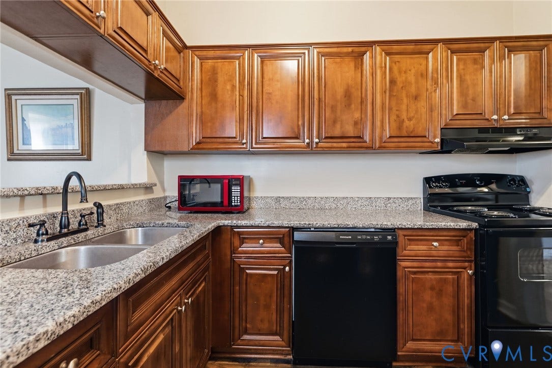 1202 1/2 W Clay Street, Richmond, VA 23220 Kitchen featuring wood cabinetry, light-toned countertops, a double basin sink with a black faucet, a black dishwasher, and a black range