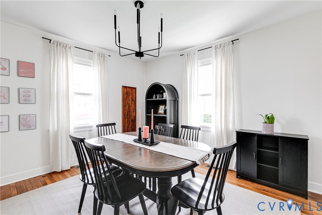 3215 Detroit Avenue, Richmond, VA 23222 Hardwood flooring with white baseboards, a contemporary black chandelier, and two windows with white window treatments