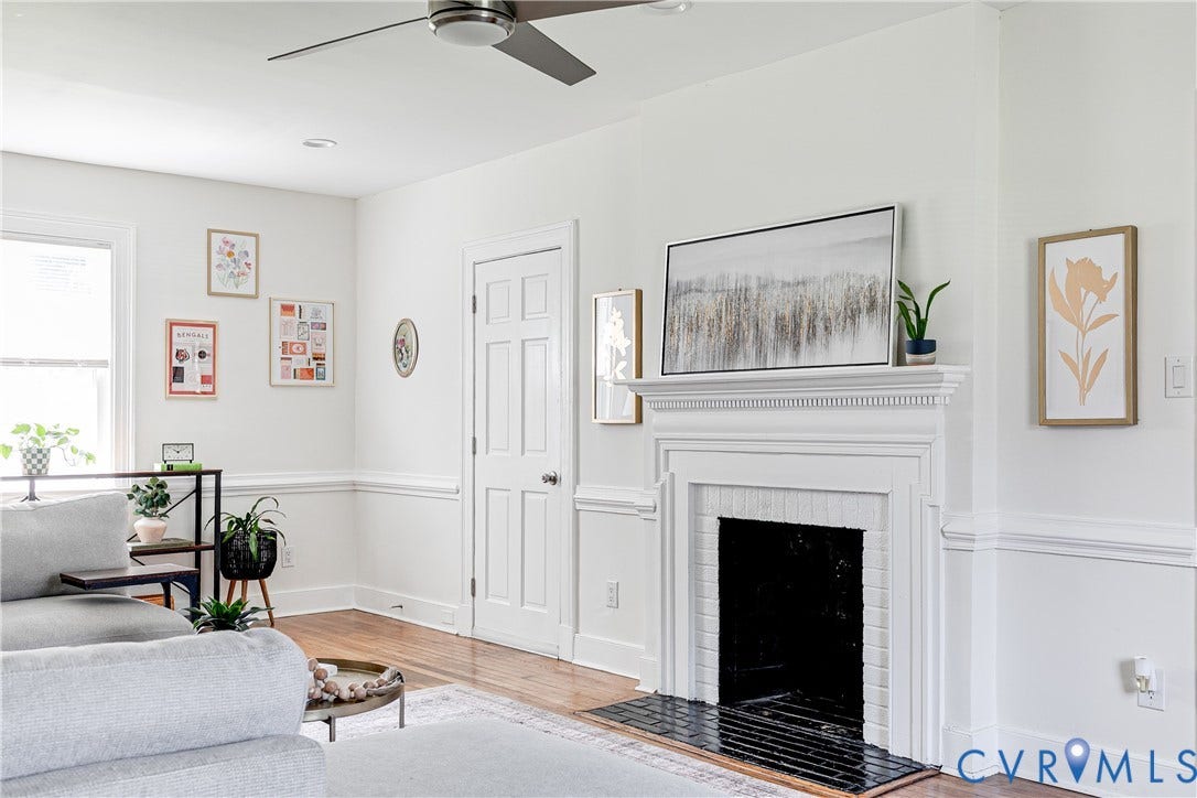 3215 Detroit Avenue, Richmond, VA 23222 Wood-finish flooring, white paneled door, fireplace with white mantel, ceiling fan, and crown molding