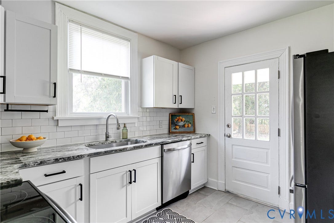 3215 Detroit Avenue, Richmond, VA 23222 White shaker-style cabinetry with matte black hardware, stainless steel appliances, granite-style countertops, subway tile backsplash, and a glass-paneled door