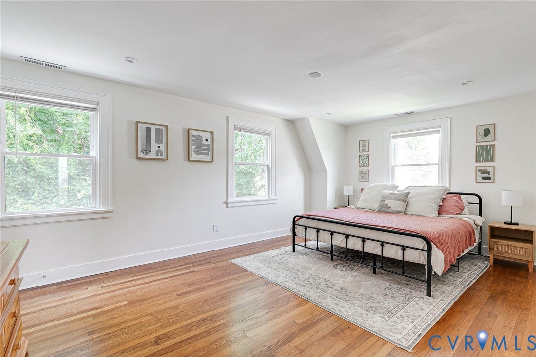 3215 Detroit Avenue, Richmond, VA 23222 Bright, airy primary bedroom featuring hardwood flooring throughout, abundant natural light from multiple windows, sloped ceiling with recessed lighting, and a neutral color palette