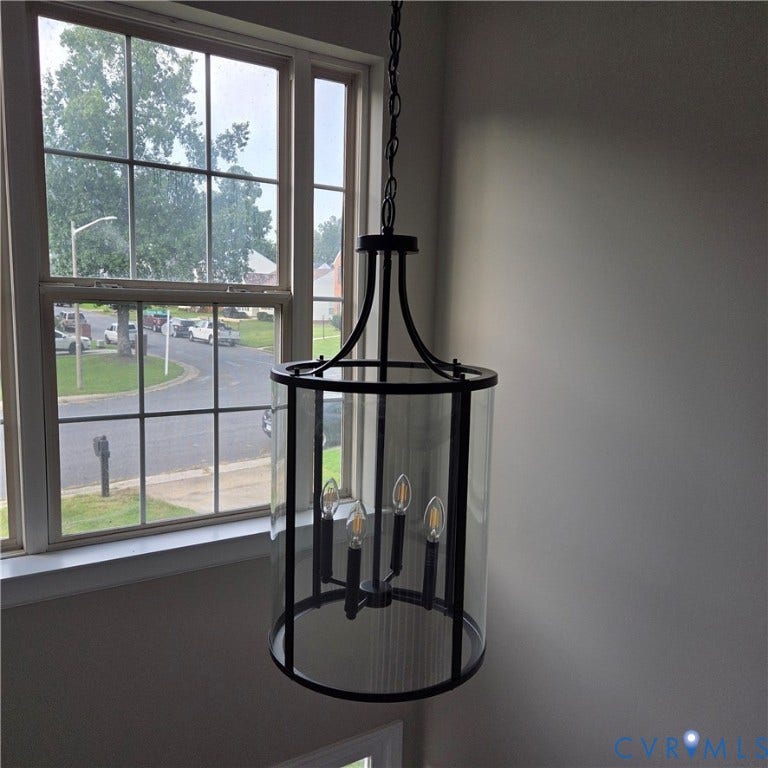 3241 Ransom Hills Road, Chesterfield, VA 23237 Black metal chandelier with clear glass cylindrical enclosure and four candelabra-style bulbs