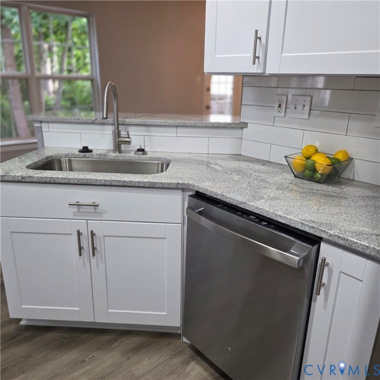 3241 Ransom Hills Road, Chesterfield, VA 23237 Modern kitchen featuring white shaker-style cabinetry, quartz countertops with waterfall edge detail, stainless steel single-basin undermount sink with chrome gooseneck faucet, subway tile backsplash, and stainless steel dishwasher