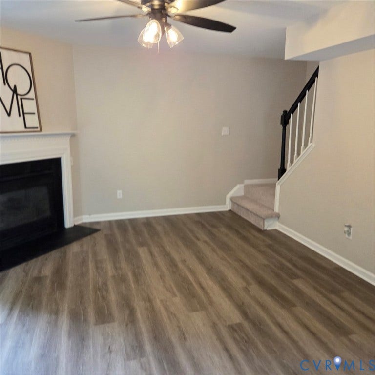 3241 Ransom Hills Road, Chesterfield, VA 23237 Wood-finish flooring, fireplace with a white mantel, ceiling fan with integrated lighting, neutral wall tones, and a carpeted staircase