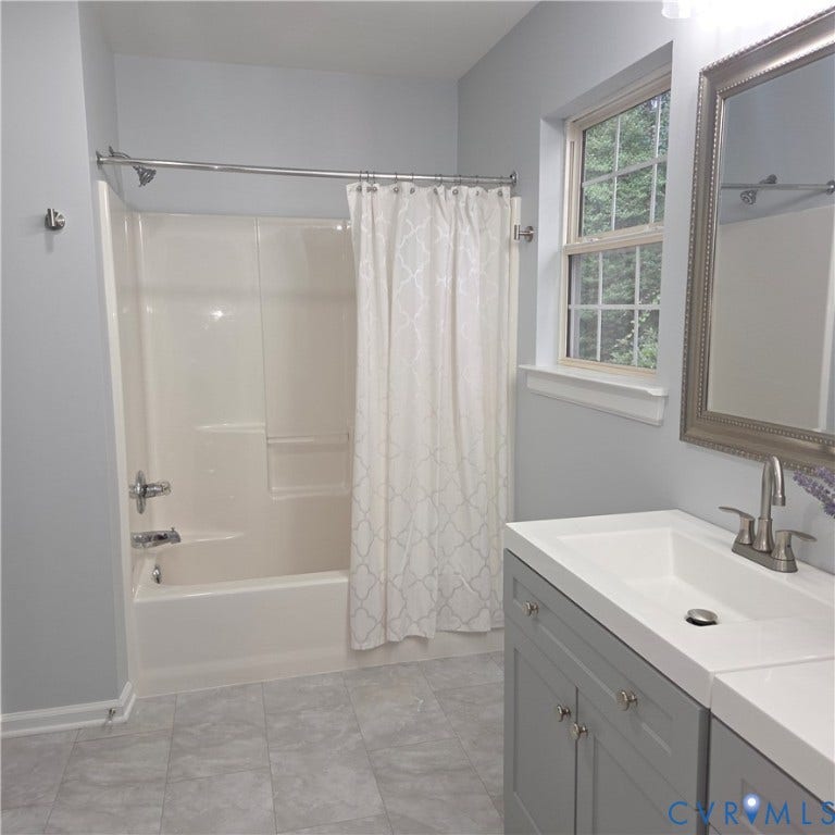 3241 Ransom Hills Road, Chesterfield, VA 23237 Integrated tub/shower combination, gray vanity with white integrated sink, chrome fixtures, and a window with natural light